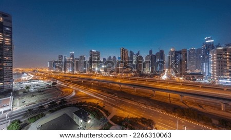 Dubai Marina skyscrapers panorama and Sheikh Zayed road with metro railway aerial day to night transition timelapse. Traffic on a highway near modern towers after sunset, United Arab Emirates