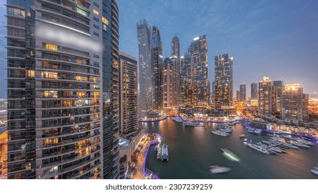 Dubai marina tallest skyscrapers with glowing windows and yachts in harbor aerial night after sunset. View at apartment buildings, hotels and office blocks, modern residential development of UAE - Powered by Shutterstock