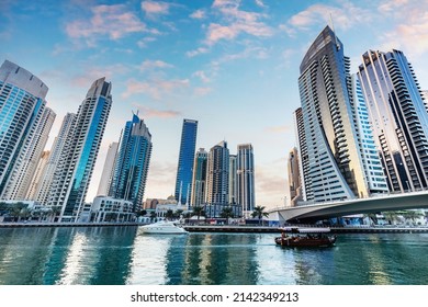 Dubai marina and tourist boat at sunset. Highrise residential buildings, business skyscrapers