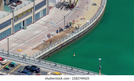 Dubai Marina Waterfront And City Promenade Repairing Timelapse From Above. Construction Workers Making A New Tile Walkway. Aerial View To Skyscrapers Along The Canals.