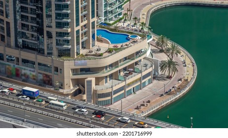 Dubai Marina Waterfront And City Promenade With Swimming Pool Timelapse From Above. Aerial View To Skyscrapers Along The Canals. Construction Workers Making A Tile Walkway