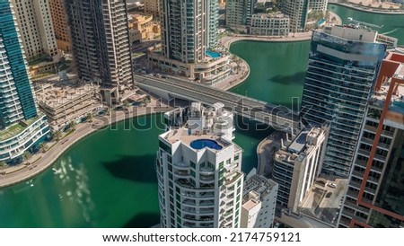 Dubai Marina waterfront and city promenade timelapse from above. Aerial view to skyscrapers along the canals. Towers rooftop with swimming pool