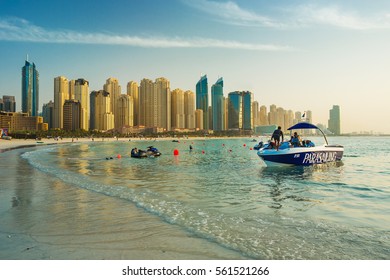 DUBAI MARINA,UNITED ARAB EMIRATES-FEBRUARY 26, 2016: View On Dubai Marina And Jumeirah Beach,where People Are Relaxing And Parasailing At The Sunset