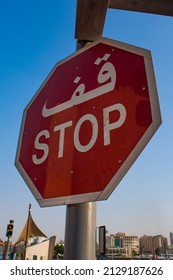 Dubai, Road Sign With STOP Text In Arabic Language Seen From Below Over The City