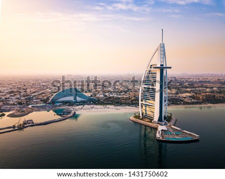 Dubai seaside skyline and Burj Al Arab luxury hotel aerial view at sunrise