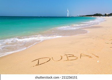 Dubai Sign On The Beach With Turquoise Water