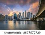 Dubai skyline. Evening mood of the arabic city. Sunset with skyscrapers in the Emirates and dramatic clouds. Glazed facade of skyscrapers. Bridge course road from the business center