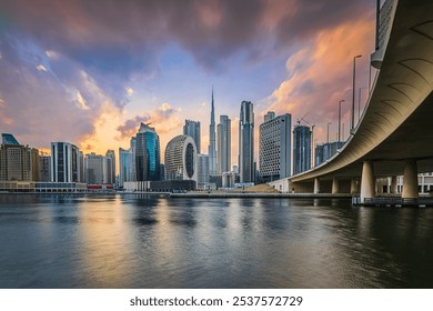 Dubai skyline. Evening mood of the arabic city. Sunset with skyscrapers in the Emirates and dramatic clouds. Glazed facade of skyscrapers. Bridge course road from the business center - Powered by Shutterstock