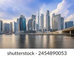 Dubai with skyscrapers and Burj Khalifa in the evening. Skyline with a cloudy sky in the evening mood. Waterfront in Dubai Harbour. Houses with glass front and concrete facades architecture