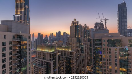 Dubai Skyscrapers With Golden Sky Over Business Bay District Day To Night Transition Timelapse. Aerial View From Of Downtown In United Arab Emirates.