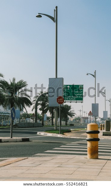Dubai\
street view with zebra crossing and palm \
trees.