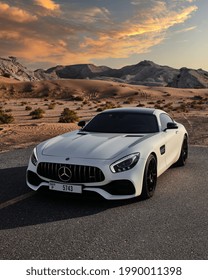 DUBAI, UAE - 01 01 2021: Mercedes GTS Luxury Car In Dubai Desert At Sunset, Mountains.