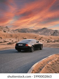 DUBAI  UAE - 01 01 2021: Rolls Royce Wraith Luxury Car In Dubai Desert At Sunset, Mountains.