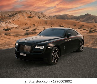 DUBAI ,UAE - 01-01-2021: Rolls Royce Wraith Luxury Car In Dubai Desert At Sunset, Mountains.