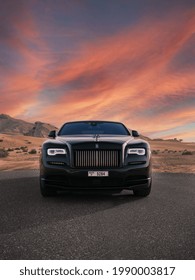 DUBAI ,UAE - 01-01-2021: Rolls Royce Wraith Luxury Car In Dubai Desert At Sunset, Mountains.