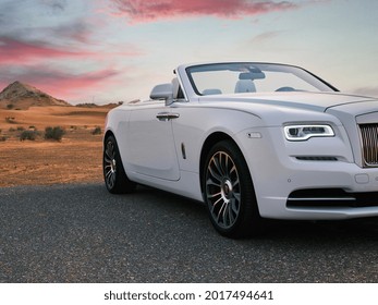 DUBAI, UAE - 07-21-21: Rolls Royce Dawn, luxury car in white in the Dubai desert, shot at sunset outdoor. 