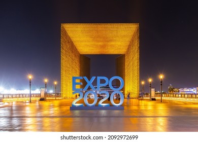 Dubai, UAE, 09.12.2021. Expo 2020 Dubai blue logo sign with illuminated entrance gateway at night.