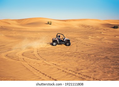 Dubai, UAE - 12.13.2014: Buggy Quad Bike Ride And Drift At Desert Sand, Leave Traces And Dust, Extreme Sports Far Away 