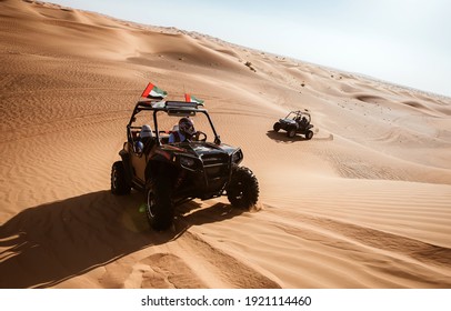 Dubai, UAE - 12.13.2014: Two buggy quad cars ride at Al Awir sand hills with emirates flags, luxury tourist fun, motor vehicle adventures   