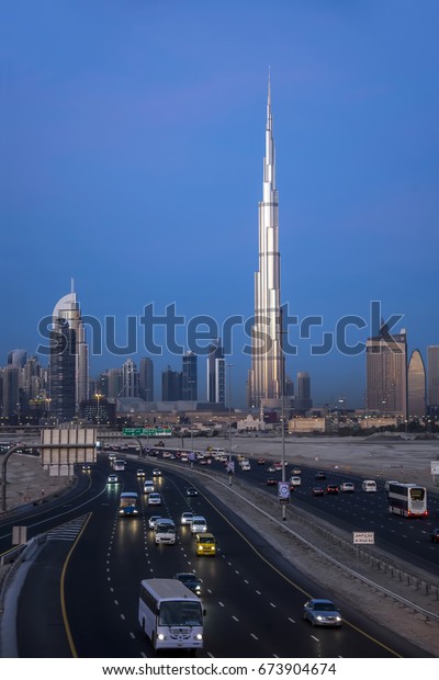 Dubai. UAE. 12/15/2014. Early morning\
traffic on Al Khail road. Burj Khalifa, the tallest building in the\
world is the first to welcome the rising\
sun.