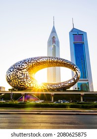 Dubai, UAE, 23 November 2021: The Museum of the Future Dubai and The Emirates Towers Hotel in the morning or sunrise. The iconic building of Dubai. With Arabic poetry on its exterior.