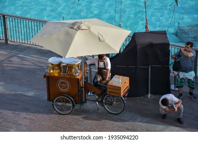 Dubai, UAE - April 15, 2018: Top view of wooden box street vending bicycle selling Nablus Kanafeh near Dubai Mall Fountain.