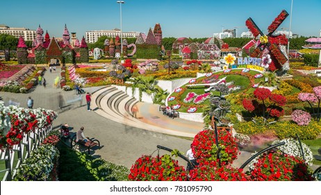 DUBAI, UAE - CIRCA JANUARY 2017: Top View Of Dubai Miracle Garden Timelapse With Over 45 Million Flowers In A Sunny Day, United Arab Emirates. Big Clock And Houses Are Made From Flowers