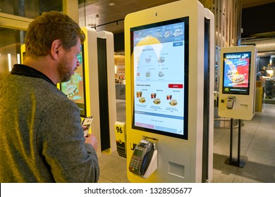 DUBAI, UAE - CIRCA JANUARY, 2019: man use self-ordering kiosks at McDonald's restaurant in Dubai International Airport.