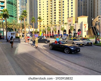 Dubai - UAE - December 11, 2020: View on JBR street. Jumeirah Beach Residence. New luxury district in Dubai. Jumeirah Beach Residence main street with a crossroad, round about, and a lot of tourists.