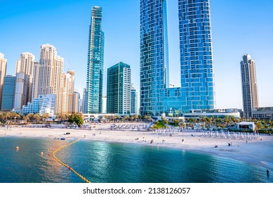 Dubai, UAE. February 10, 2022. Famous Address Beach Resort With Jumeirah Beach Residences Along With Tourists Sunbathing On Sand