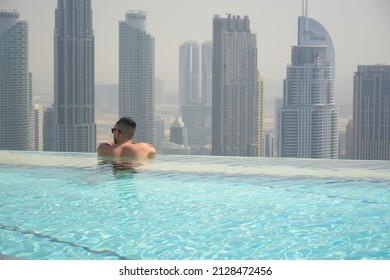 Dubai, UAE - February 3, 2022: Men is enjoing city view from the swimming pool in Ce La Vi rooftop restaurant located in Address Sky View hotel