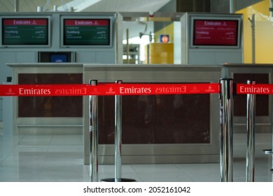 Dubai, UAE - Jun 2010: View Of Red Queue Retractable Belt Barrier With Emirates Airlines Logo At Departure Gate In Dubai International Airport Terminal. Bokeh Background. No People.