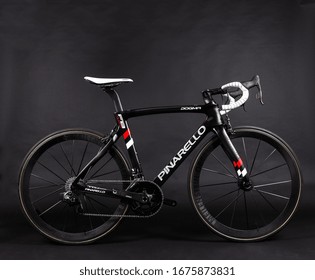 Dubai / UAE - March 05 2018: Pinarello Racing Bicycle, Carbon Fiber Bike In Black Shot On A Black Background, With White Bar Take And Red Decals. Tour De France Racing Bike Isolated On Black