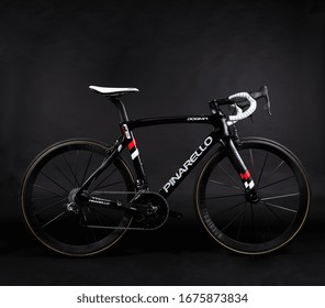 Dubai / UAE - March 05 2018: Pinarello Racing Bicycle, Carbon Fiber Bike In Black Shot On A Black Background, With White Bar Take And Red Decals. Tour De France Racing Bike Isolated On Black