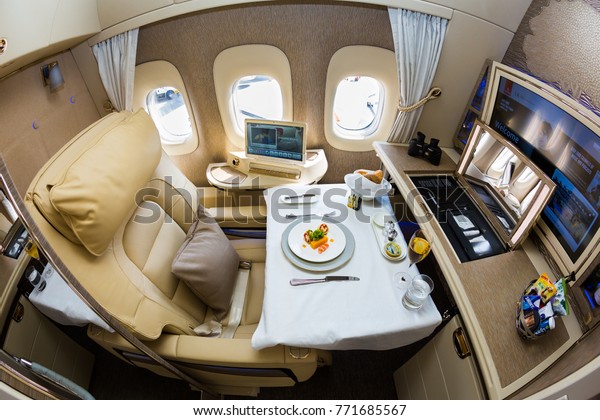 Dubai,\
UAE - NOVEMBER 14, 2017: Emirates new first class suite. Emirates\
luxury travel. Boeing 777. Onboard dining, food. Renewed first\
class cabin. Brand new design. First class\
seat.