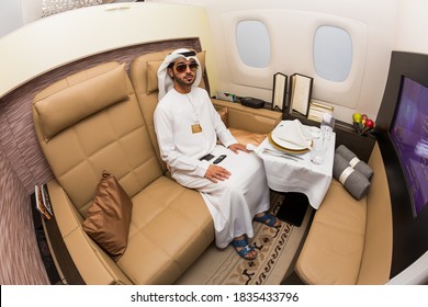 Dubai, UAE - NOVEMBER 15, 2017: Arab businessman wearing national dress travelling in business class. Business class flight. VIP travel. Airline first class cabin interior. Arab sheikh lifestyle.