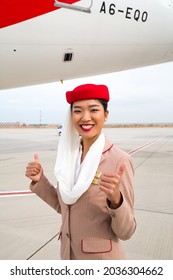 Dubai, UAE - NOVEMBER 21, 2019: Smiling Flight Attendant. Emirates Airline Cabin Crew Member. Emirates Stewardess Standing Near Aircraft. 