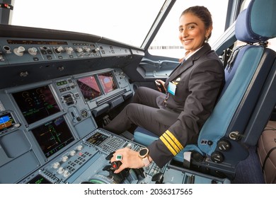 Dubai, UAE - NOVEMBER 21, 2019: Female pilot in the cockpit of modern aircraft. Pilot at work. Travel by plane. Flight. Smiling woman pilot.  