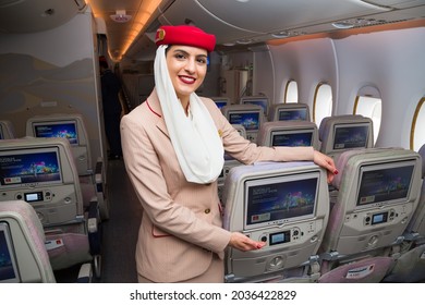 Dubai, UAE - NOVEMBER 21, 2019: Smiling Flight Attendant. Emirates Airline Cabin Crew Member. Emirates Stewardess Welcoming Passengers Aboard 