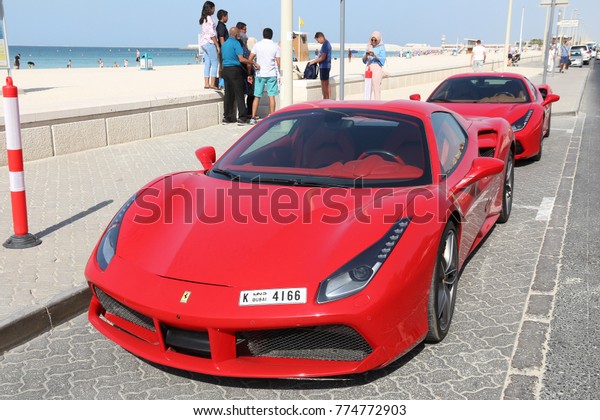 DUBAI, UAE - NOVEMBER 23,
2017: People walk by Ferrari 488 GTB in Dubai, United Arab
Emirates. Dubai city has a car ownership rate of 541 cars per 1,000
population.