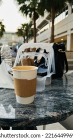 Dubai, UAE - Oct 20, 2022 : White Coffee Cup On Table With Purse And Flying Tissue