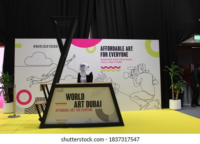 Dubai, UAE - October 10, 2020: Customer Service Agent Wearing Face Shield And Face Mask As A Health Precaution At 'World Art Dubai' Affordable Retail Art Fair, During The Global Covid-19 Pandemic.