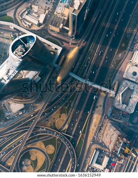 DUBAI, UAE - OCTOBER 2019: Birds eye\
view of Sheikh Zayed Road in Dubai showing futuristic buildings\
under construction and the Dubai Metro with ongoing\
traffic