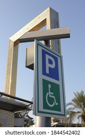 Dubai, UAE - October 31, 2020: Handicapped Parking Sign Near 'Dubai Frame' Iconic Landmark. The 150x93m Hxw Rectangular Golden Steel And Glass Structure Features The Ring Pattern Of Expo 2020 Logo.