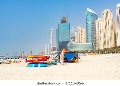 Dubai, UAE - October 5, 2019 - Marina Public Beach And Skyscrapers. Entertainment Parasailing, Banana Ride, Water Slide, Trampoline