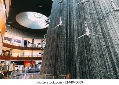 Dubai, UAE, United Arab Emirates - May 22, 2021: View Of Waterfall With Figures Of Divers In The Dubai Mall. Fountain In The Dubai Shopping Mall Pearl Divers, Pearl Diver. Landmark Of Downtown 