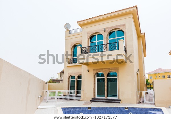 Dubai / United Arab Emirates - 02-27-2019 : state of\
the art, big yellow villa house in dubai, in the villa project\
Dubai. The house has a Swimming pool and a private covered car\
parking area