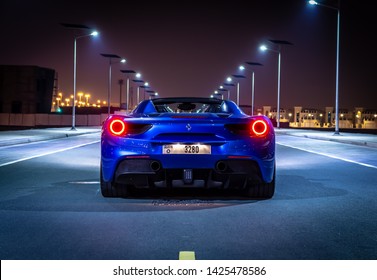 Dubai, United Arab Emirates - 06/14/2019: Rear view of Ferrari 488 Spider convertible supercar parked at night on a Dubai street
