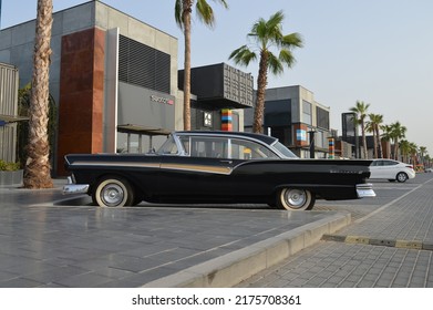 Dubai, United Arab Emirates - 26 06 16: Vintage Car Parked At A Trendy Outdoor Strip Mall In Dubai, Set Against A Backdrop Of Palm Trees, Resutrants, And Shops.