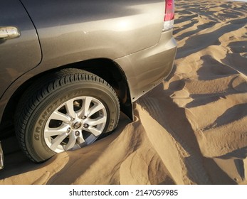 Dubai, United Arab Emirates - April 18, 2022: Off-road 4x4 Vehicle (four-wheel-drive, 4WD, SUV) Sinking And Stuck In Deep Desert Sand Dunes Terrain. The Vehicle Needs To Be Towed Out Or Shoveled Out.